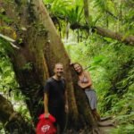 Guests walking through tropical forest on guided hike in Aik Berik village