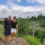 Guest standing on ridge along hiking trail to hidden waterfalls in Lombok